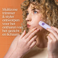 Vrouw met krullend haar gebruikt een paarse multitool trimmer en styler op haar gezicht.